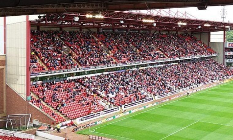 East stand of Oakwell stadium taken from North with fans and view of pitch